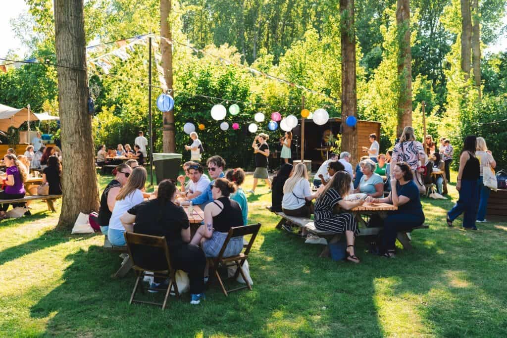 Mensen genieten van een drankje en gesprek in een ontspannen setting, een locatie die zowel gewaardeerd wordt voor vergaderingen als voor informeel contact – ideaal voor iedereen die zoekt naar bijzondere vergaderlocaties met sfeer.